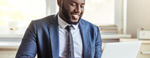 businessman in suit is using a laptop and smiling while working