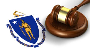 Massachusetts US state law, code, legal system and justice concept with a 3d render of a gavel on the Massachusite flag on background.