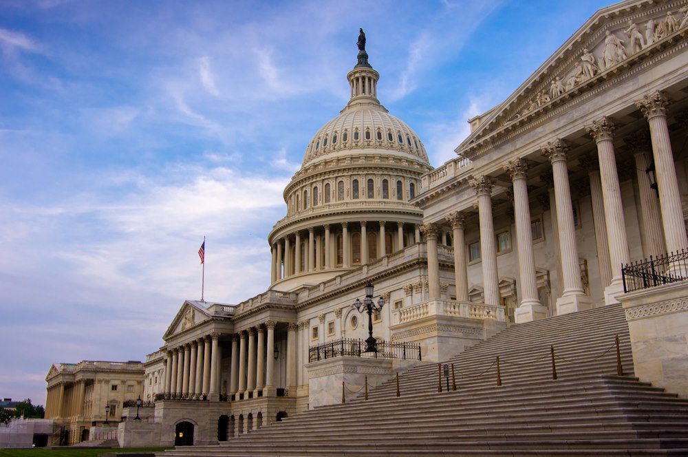 Low angle view of the east entrance to United States Capitol building in Washington DC with marble dome and stairs