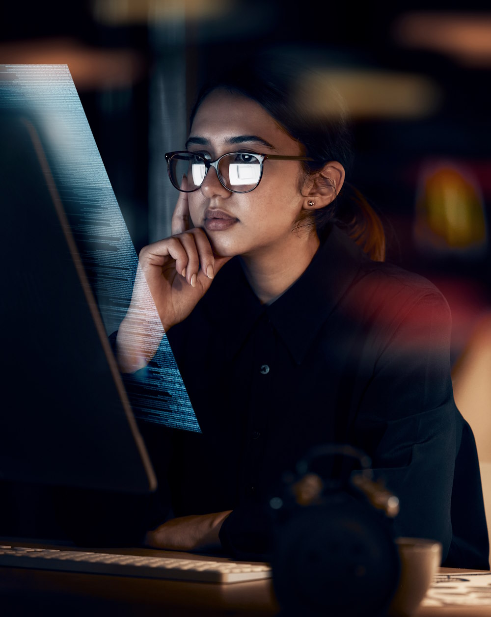 A woman looks at a futuristic computer screen where the image is projected out towards the user.