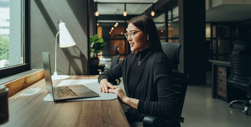 Businesswoman attending a virtual meeting in a modern co-working office.